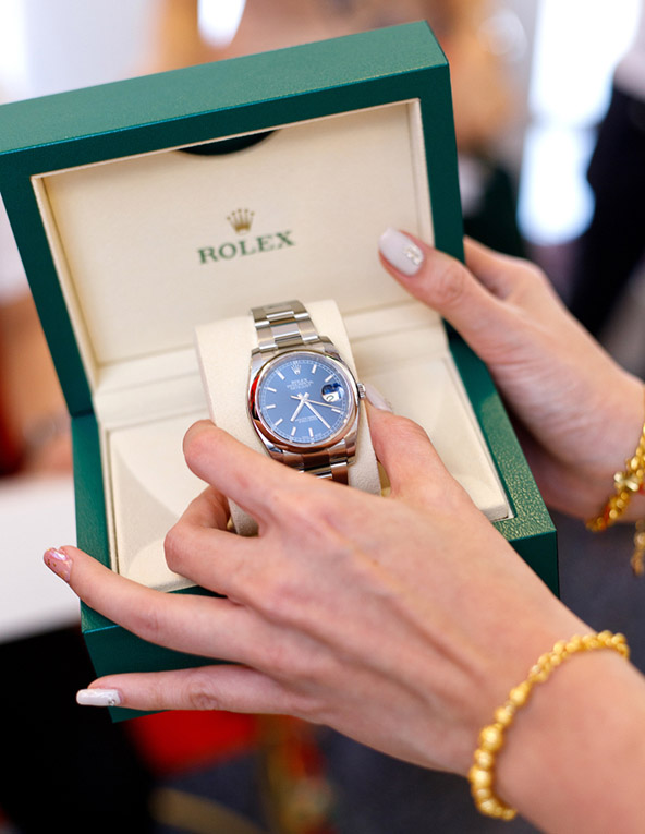 female hand holding new Rolex