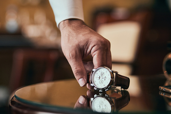 man picking up a wrist watch