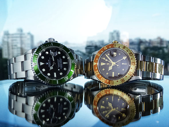 pair of rolex watches with a reflective surface