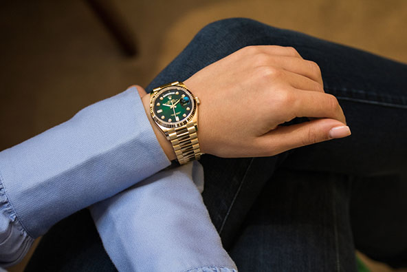 woman wearing gold rolex watch